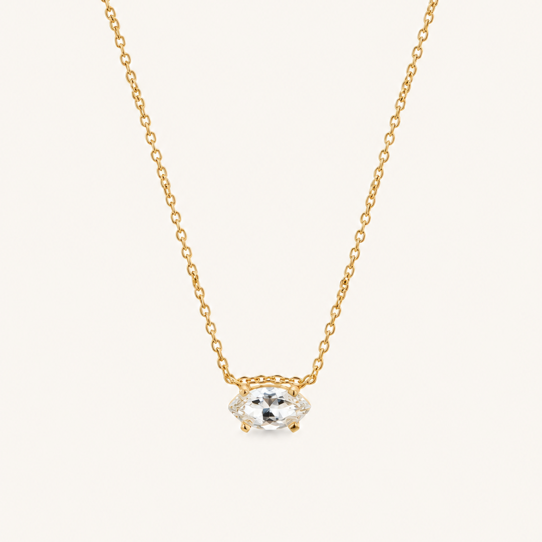 Close up of a natural white sapphire necklace on a delicate gold chain.