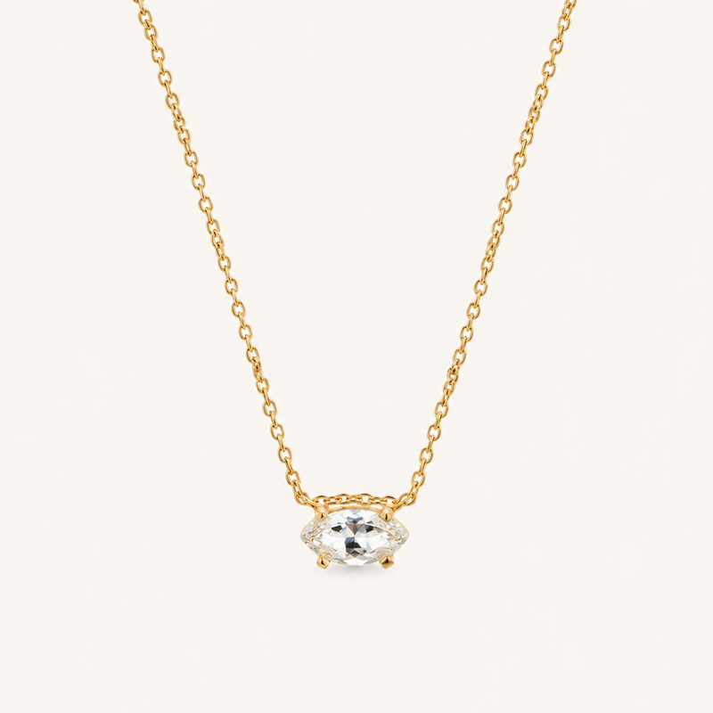 Close up of a natural white sapphire necklace on a delicate gold chain.