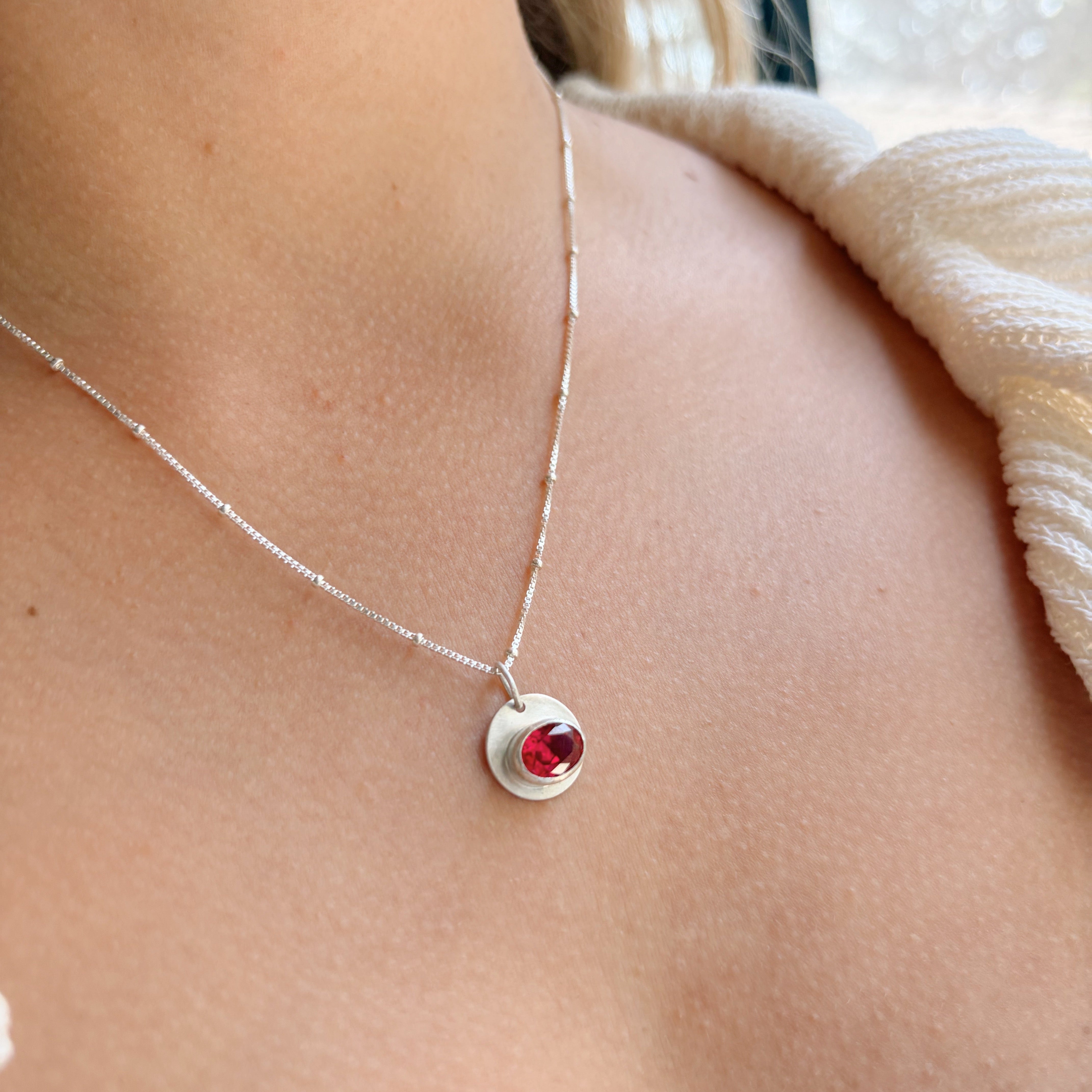 Silver bezel set pink lab grown ruby necklace on model