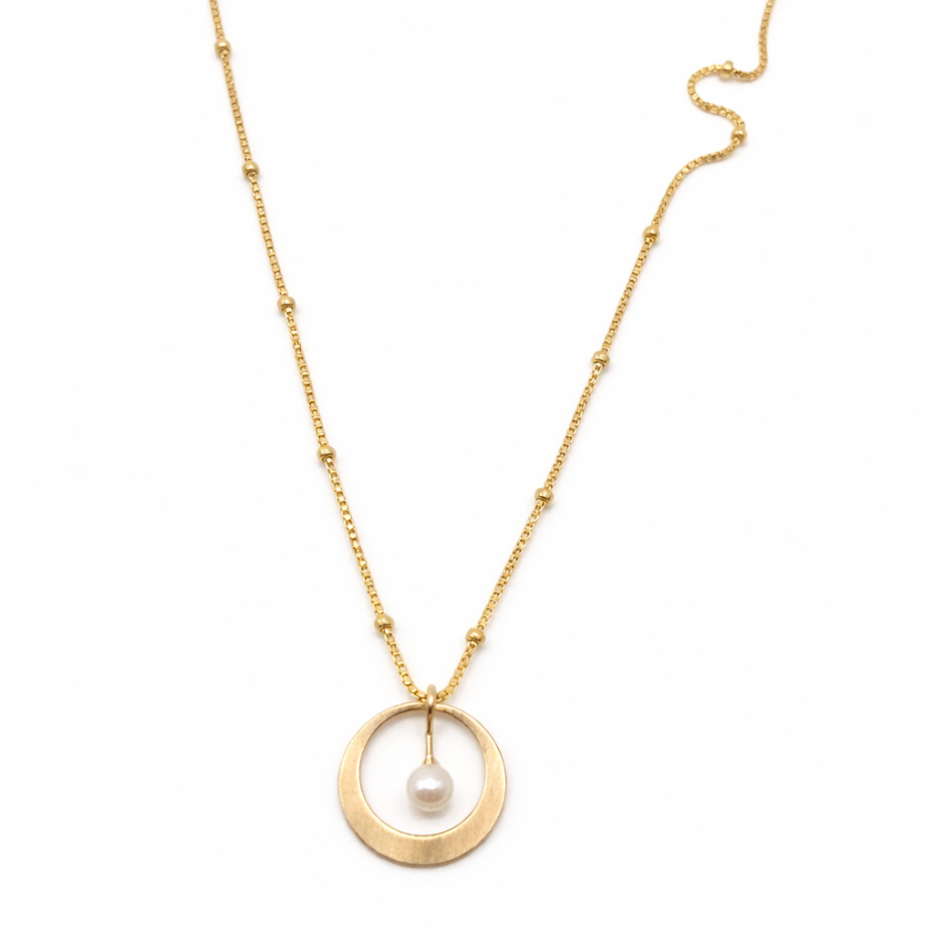 Gold necklace with a circle shape and pearl inside pendant