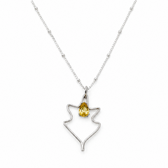 A silver necklace with minimal leaf-shaped pendant with a yellow gemstone at the center.