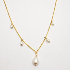 Gold necklace with pearls on a white background