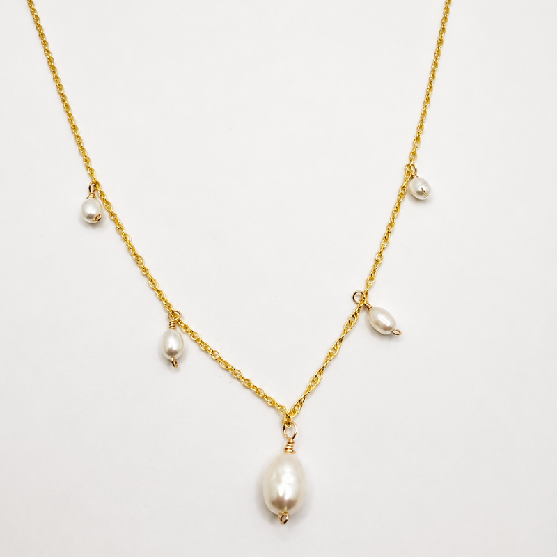 Gold necklace with pearls on a white background