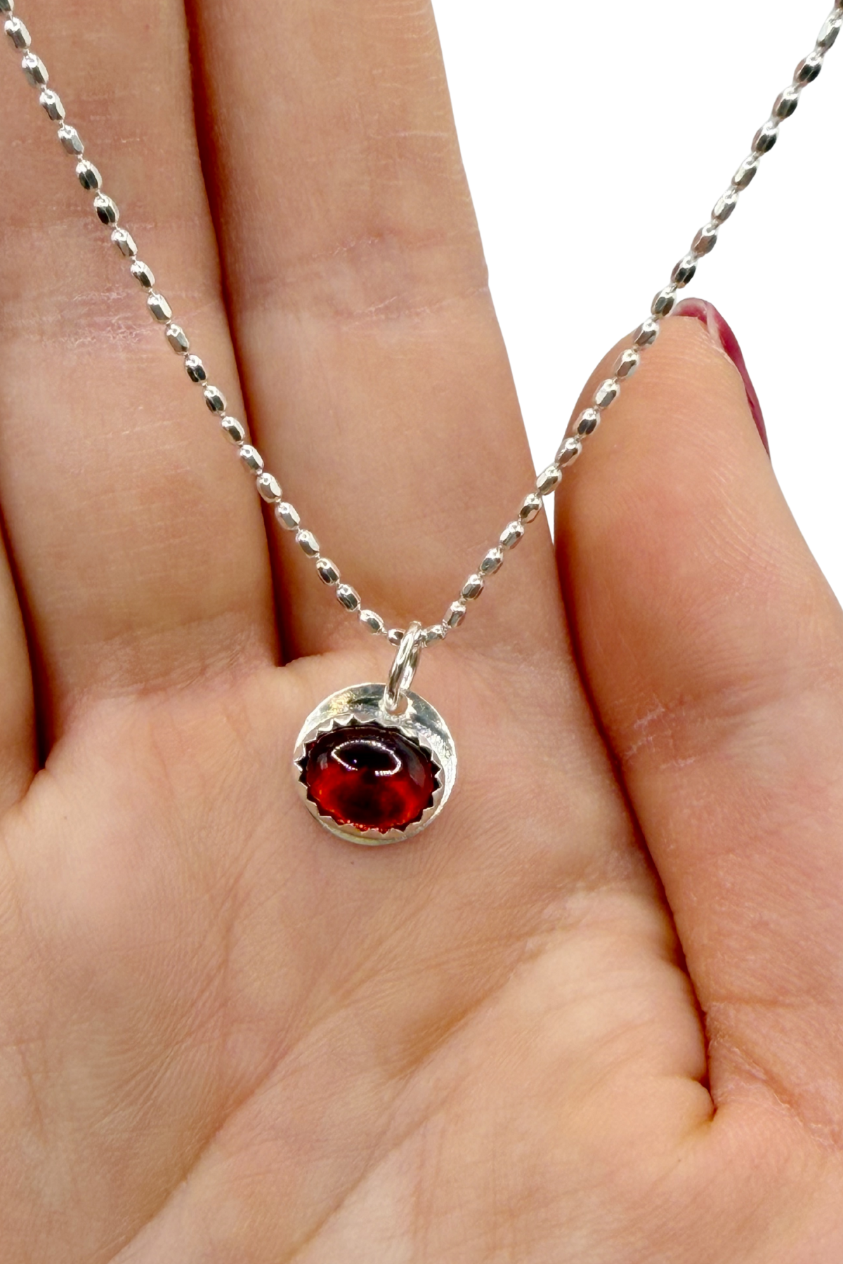 Silver necklace with a red gemstone pendant