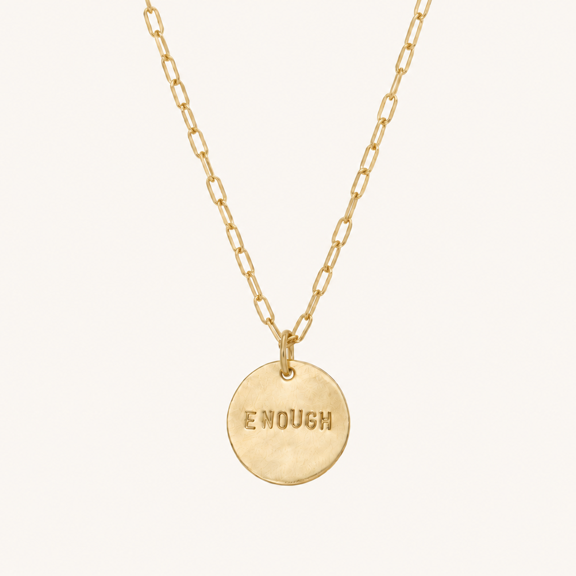 Gold necklace with the word enough on the pendant
