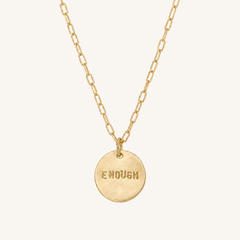 Gold necklace with the word enough on the pendant