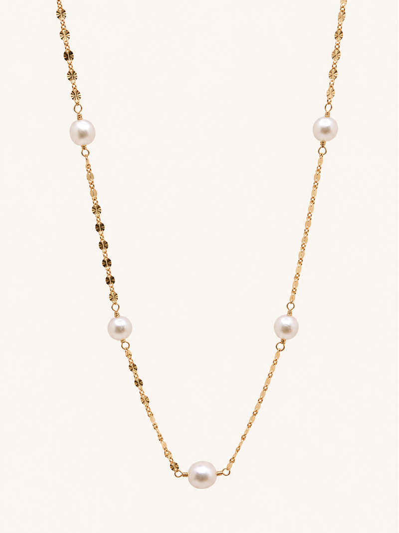 A delicate gold chain necklace featuring five evenly spaced white freshwater pearls